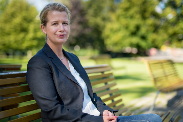 Kvinna sitter på en parkbänk.