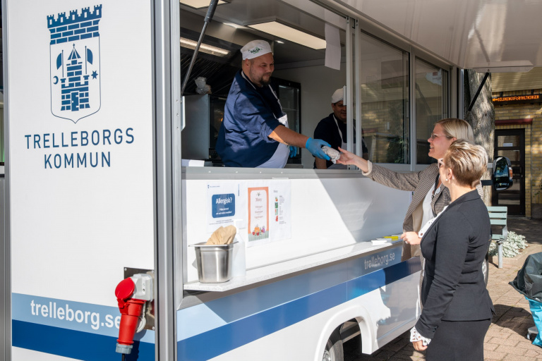 Måltidspersonalen serverar lunch från den mobila foodtrucken.