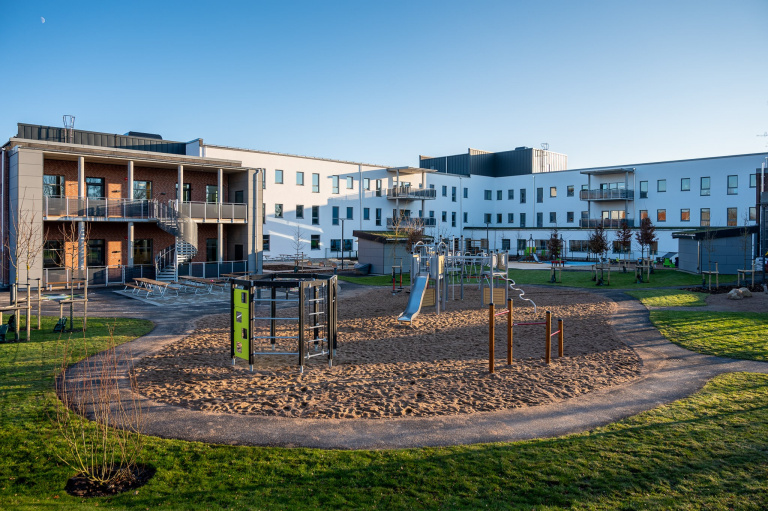 lekplats framför vitt hus