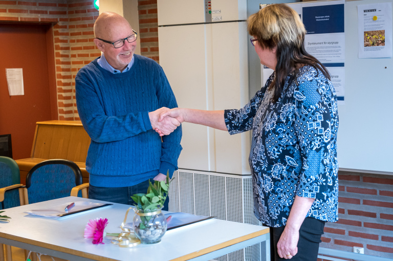 Man och kvinna skakar hand.