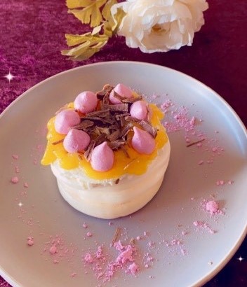 Dessert vackert presenterad på ljus tallrik.
