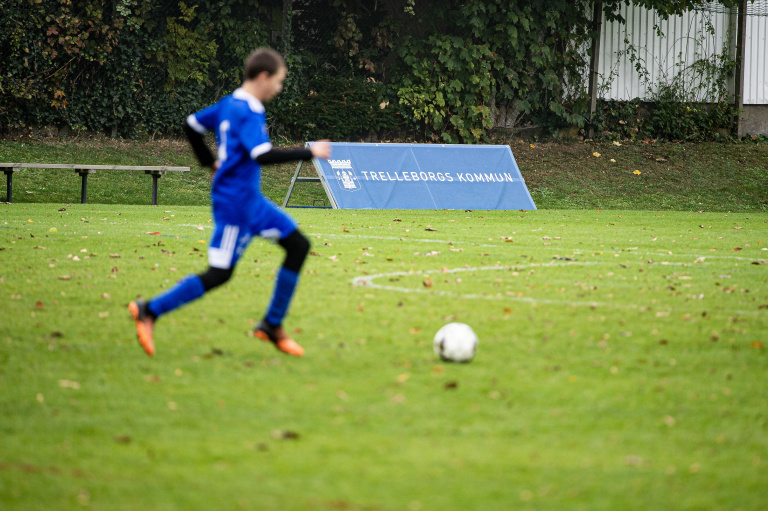Kille i blå kläder på fotbollsplan