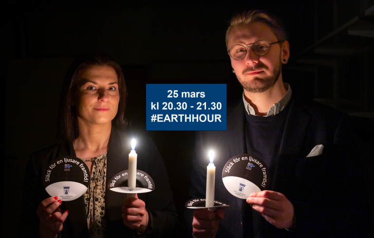 två personer i mörker med tända ljus, earth hour