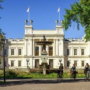 Utomhus, byggnad, träd, tre cyklande människor
