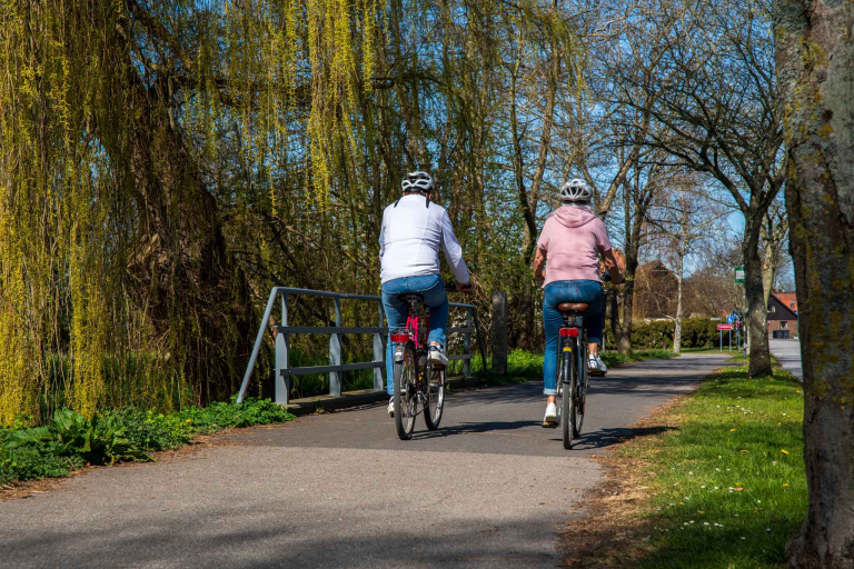 två cyklister bakifrån på cykelväg.
