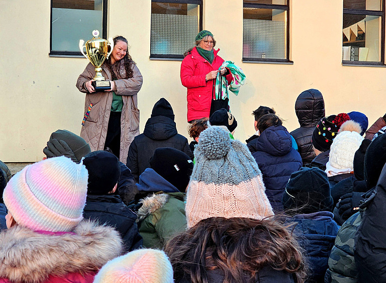 två kvinnor framför publik av barn