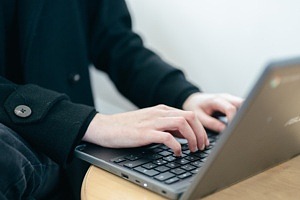 händer vid laptop