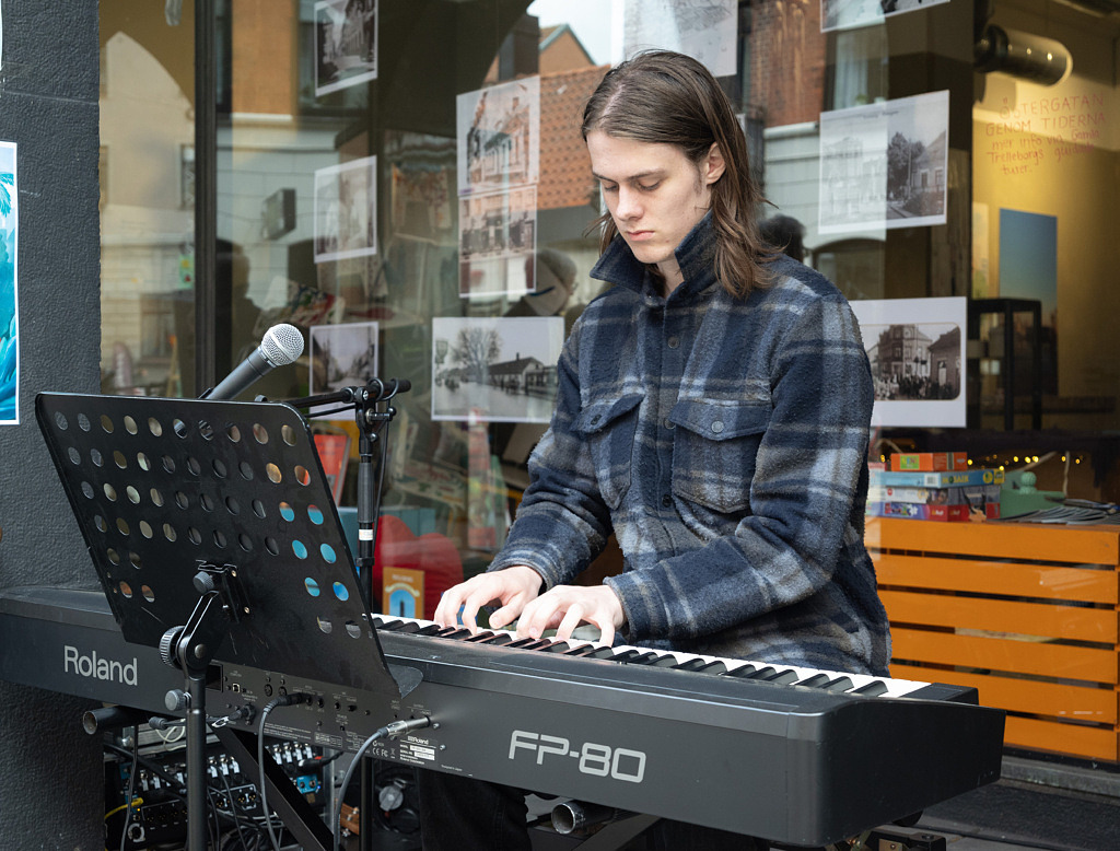 Ung man sitter och spelar piano.