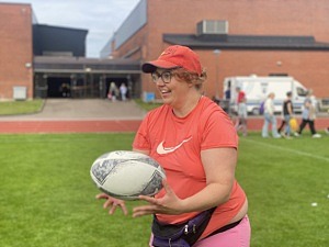 kvinna med rugbyboll i händerna.